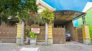 A gated entrance with a sign reading "TERIMA KOS PUTRI" and a parked car. - OYO LIFE 91551 Gwen Syariah Homestay (Jogoroto)
