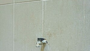 A tiled wall with a damaged section where a pipe has been exposed. - OYO Life  92091 Citra Omah Syariah (Malang)