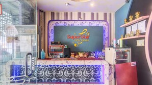 A family karaoke bar with a 'SuperStar' sign, a glass display case, and a patterned counter. - Hotel O Superstar Kost Dan Homestay (Tomohon)