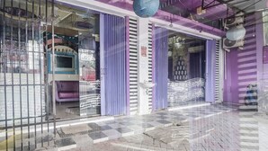 A hotel entrance with purple curtains, a tiled floor, and a vending machine. - Hotel O Superstar Kost Dan Homestay (Tomohon)