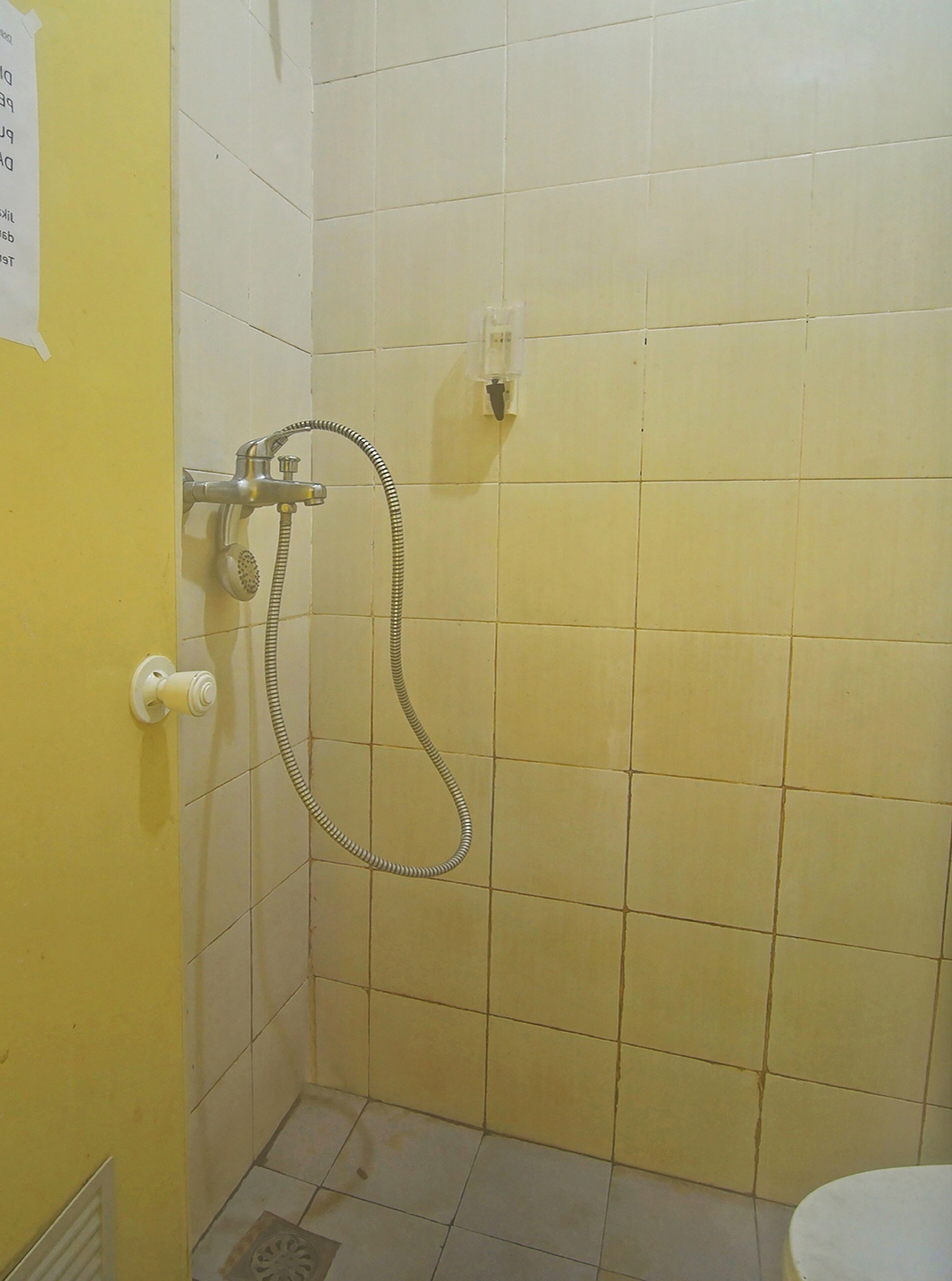 Un baño pequeño con azulejos, una ducha y un inodoro.