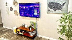 A living room with a flat-screen TV, a chessboard, and a map of the United States on the wall. - 4 Bed Large Backyard Near Airport & AT&T Stadium (Bedford)