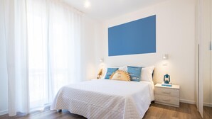A bedroom with a bed, bedside tables, and a nightstand. - Nida 18 in Cattolica (Cattolica)