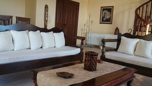 A room with a large bed, two sofas, a wooden coffee table, a radiator, and a staircase. - Cozy Apollon Villa, Sea View, Next To Galaxidi (Phocis)