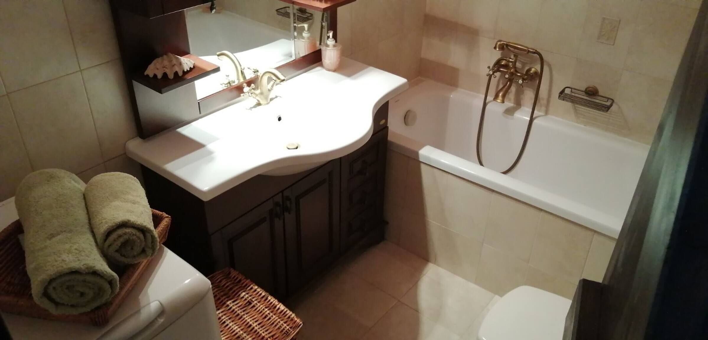 Une salle de bain avec un lavabo, un miroir et une baignoire.
