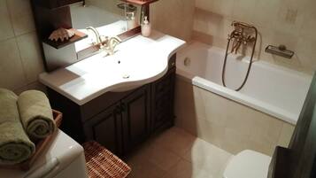 Une salle de bain avec un lavabo, un miroir et une baignoire.