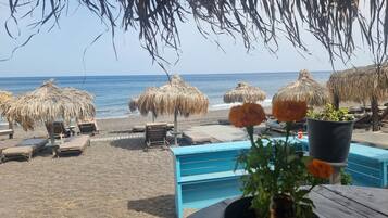 Am Strand, schwarzer Sandstrand, Shuttle zum Strand, Liegestühle