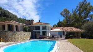 A modern house with a swimming pool, stone walls, and a garden. - Villa zu Vermieten in Porto del Almendros, Los Arqueros, Benahavis (Benahavís)