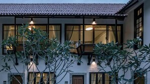 A two-story building with large windows, a tiled roof, and a well-maintained lawn. - Palin Family Cottage (Chiang Rai)