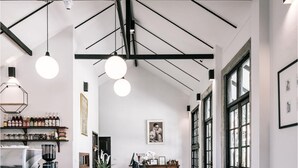 A spacious kitchen with a marble floor, a coffee machine, and a wooden counter. - Palin Family Cottage (Chiang Rai)