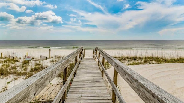 A wooden boardwalk leading to a beach with a clear sky. - By the Sea, on Perdido Key Dr! (Pensacola)