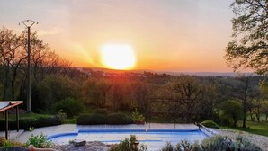 A poolside area with two striped lounge chairs facing a sunset view. - Great house with beautiful (sundowner) view (Saint-André-d’Olérargues)