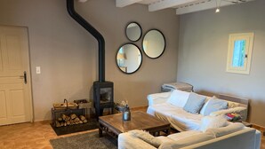 A cozy living room with a fireplace, a sofa, a coffee table, and a rug. - Great house with beautiful (sundowner) view (Saint-André-d’Olérargues)