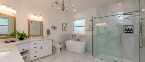 Een moderne badkamer met een groot bad, een douche met glazen wanden en een wastafel met spiegel.