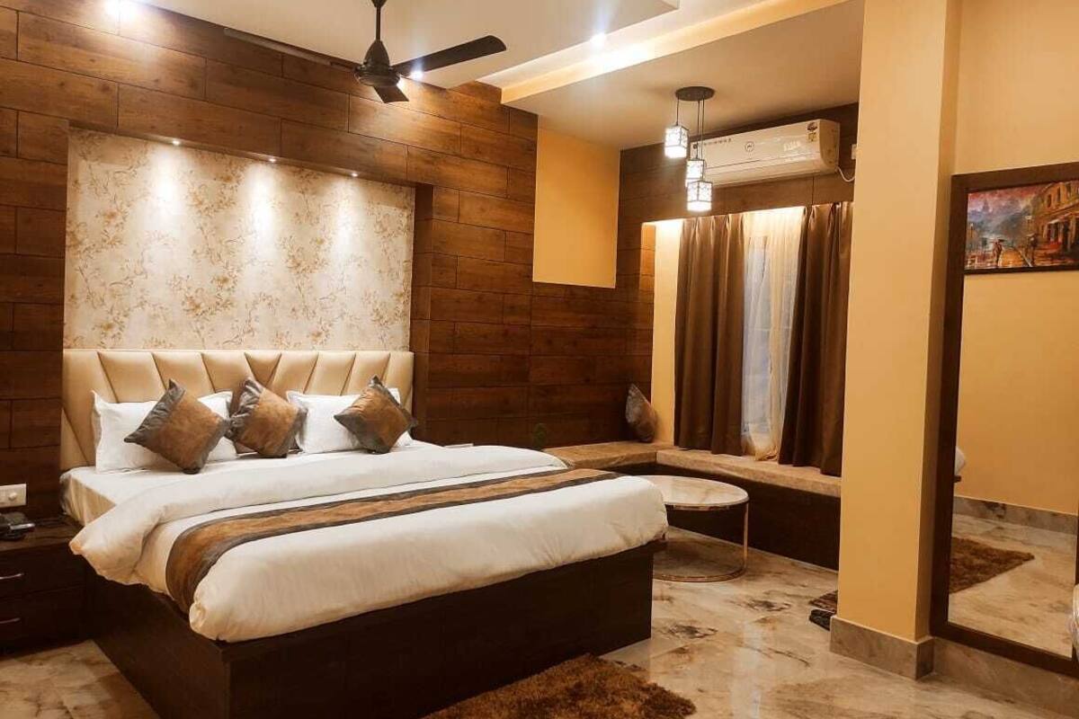Un dormitorio moderno con una cama grande, un ventilador de techo y un banco empotrado.
