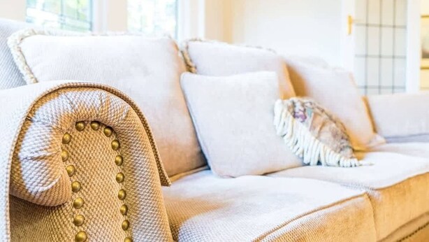 A beige sofa with a textured armrest and a decorative pillow. - Cambridge House, Bendigo (Bendigo)