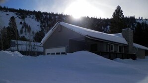 Un edificio amplio de una sola planta con techo inclinado, rodeado de nieve.