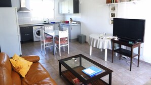 Een knus woongedeelte met keuken, eethoek en televisie.