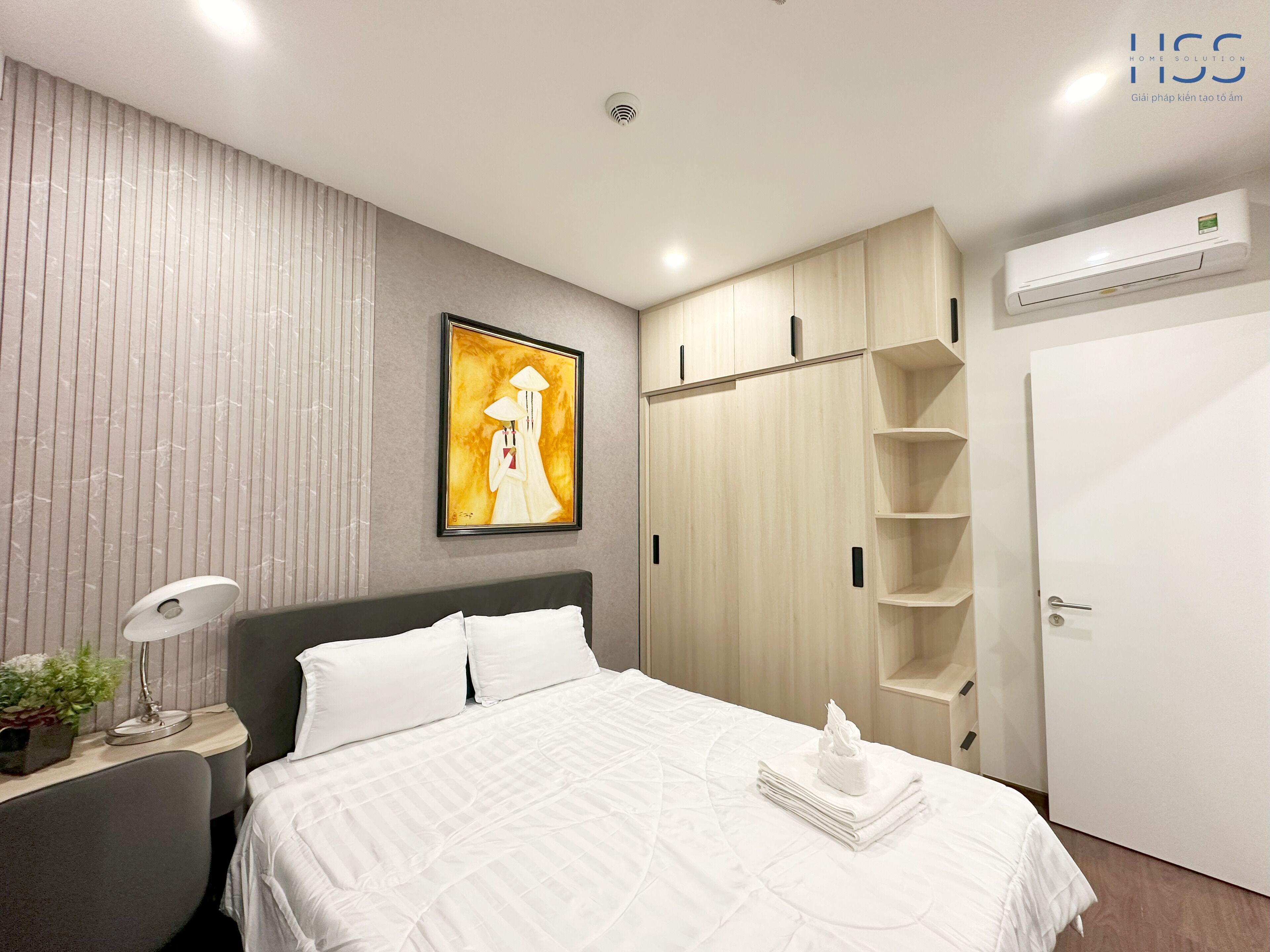 Ein modernes Schlafzimmer mit einem Bett, einem Nachttisch, einer Lampe und einem Bild an der Wand.