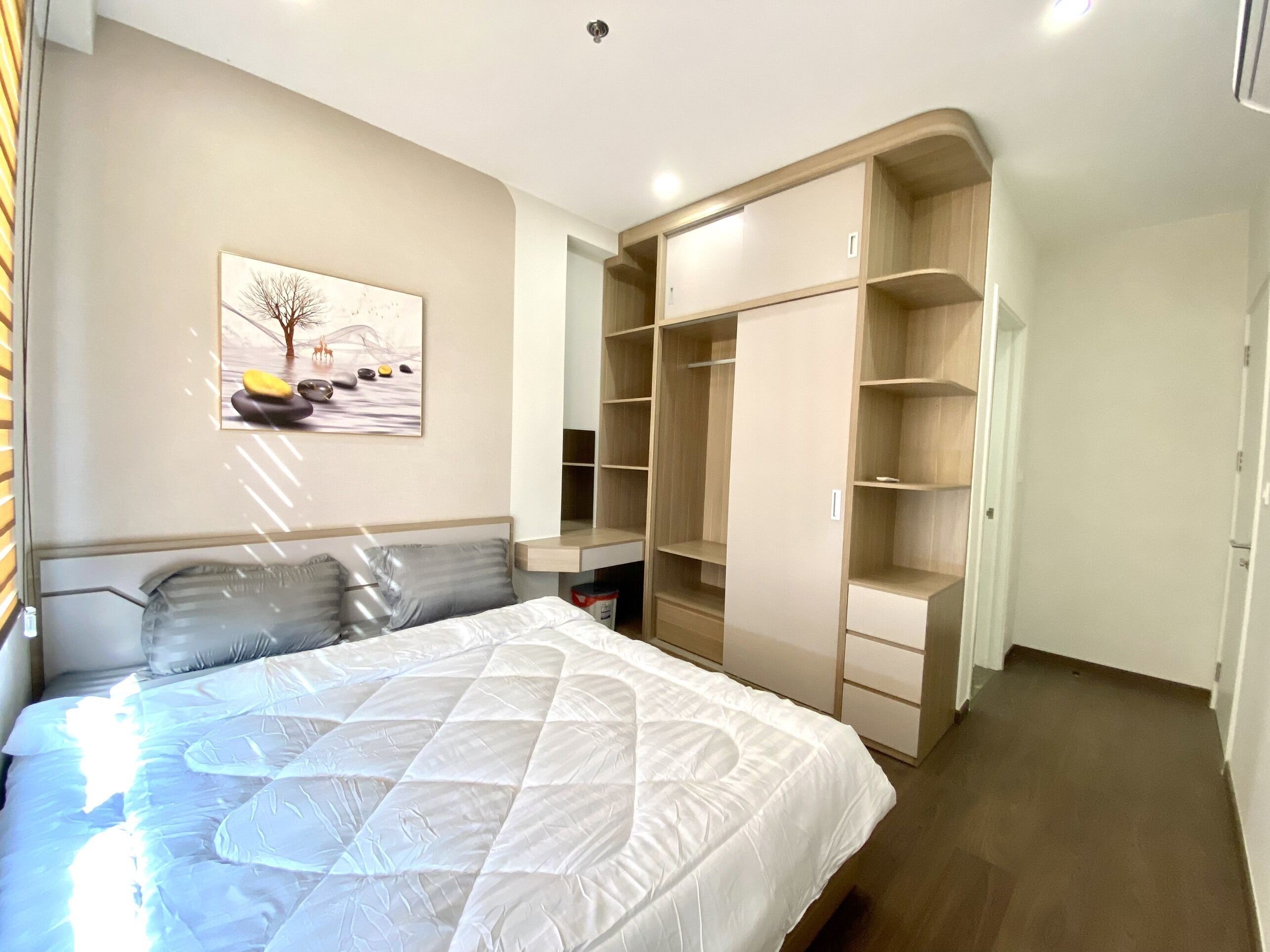 Ein Schlafzimmer mit Bett, einem Bild an der Wand und integrierten Holzhüllen.