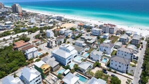 Ein Luftbild einer Küstenwohngegend mit Gebäuden, einem Strand und einem klaren, blauen Meer.
