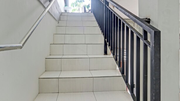 A staircase with white steps and black railings, leading to an upper floor. - OYO 90517 Homestay Wonosobo Asri (Wonosobo)