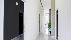 A corridor with doors numbered 6 and 2, leading to rooms. - OYO 90517 Homestay Wonosobo Asri (Wonosobo)