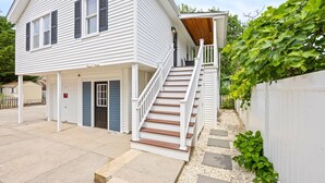 Une maison à deux étages avec un porche et un escalier menant à l’étage supérieur.