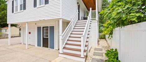 A two-story house with a covered porch and a staircase leading to the second floor.