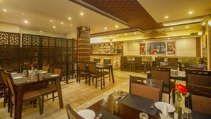A restaurant with wooden furniture, a bar area, and decorative screens. - NRS KINGSTON (Gangtok)