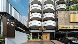 A multi-story building with a modern design, featuring balconies and a sign that reads "S+AY PLUS". - Stay Plus Hotel Bangkok (Bangkok)