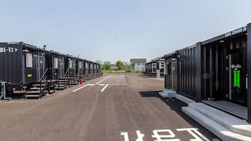 A parking lot with rows of black shipping containers, each marked with a number.