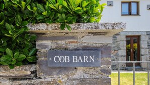 A stone wall with a sign reading "COB BARN". - Great Brightor Cob Barn (Bodmin)