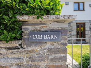A stone wall with a sign reading "COB BARN". - Great Brightor Cob Barn (Bodmin)