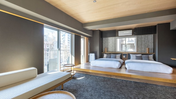 Un dormitorio moderno con una cama grande, un sofá y una pequeña mesa.