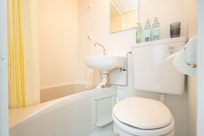 A modern bathroom with a white bathtub, sink, and toilet. - ZAITO Tokyo Luna Lane Economy Inn (Tokyo)