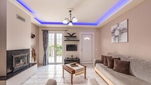 Ein Wohnzimmer mit Kamin, Sofa und Fernseher.