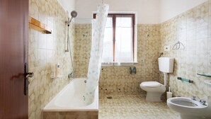 A bathroom with a bathtub, toilet, and bidet. - Holiday Home "Casa Degli Zii Appartamento Guido" with Shared Terrace, Balcony & Wi-Fi (Luni)