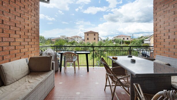 A covered outdoor patio with a brick wall, a sofa, a table, and chairs. - Holiday Home "Casa Degli Zii Appartamento Guido" with Shared Terrace, Balcony & Wi-Fi (Luni)