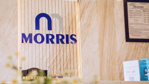Una mesa de recepción con un letrero que dice "MORRIS" y un menú enmarcado en la pared.