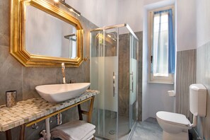 A bathroom with a large mirror, a vessel sink, a glass-enclosed shower, a toilet, and a window. - Villa "Luxury Oleandra" with Private Pool, Big Garden and Barbecue (Dizzasco)