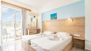 A hotel room with two beds, a bathroom, a balcony with a chair, and a painting on the wall.