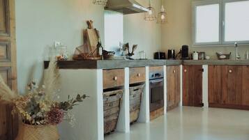 Una cocina con armarios de madera, horno empotrado y un ventanal grande.