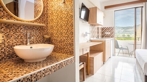 Une salle de bain avec un mur recouvert de mosaïques, un grand miroir et un lavabo.