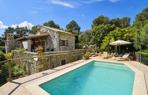 A stone house with a swimming pool, outdoor furniture, and a garden. - Villa 'Sa Garriga De Can Barratot' with Mountain View, Wi-Fi and Air Conditioning (Selva)