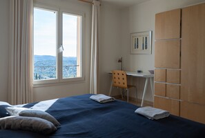 Quarto com cama, escrivaninha e guarda-roupa.
