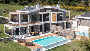 A modern two-story house with a swimming pool, outdoor seating, and a stone facade. - K-Koni Villa, Agia Paraskevi by Halkidiki Villas (Pallini)