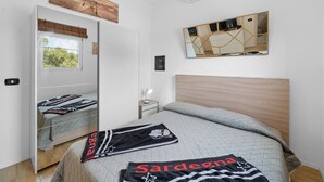 A bedroom with a bed, a mirror, a window, and a wardrobe. - Holiday Home 'Villa Matteo' with Sea View, Wi-Fi and Air Conditioning (Perd'e Sali CA)