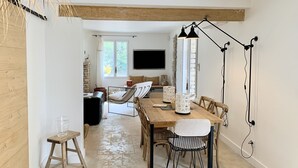 A dining area with a wooden table, chairs, and a hanging light fixture.