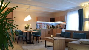 A modern living room with a sofa, coffee table, and dining area. - 3 Raum Appartement Hotel Garni am Domplatz (ERfurt)